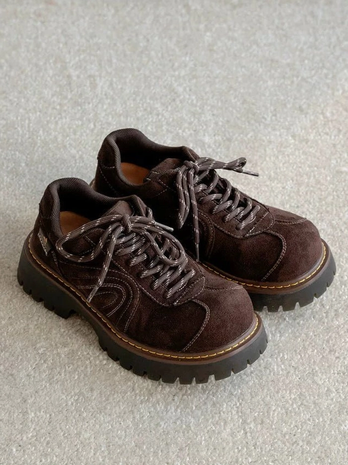 Pair of brown chunky suede-effect platform sneakers with contrast laces, yellow midsole stitching, and rugged rubber lug outsole shown from above