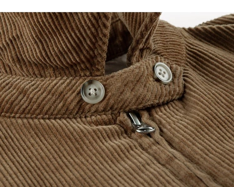 Angled close-up of brown corduroy Harrington jacket collar strap fasteners round buttons and metal zipper hardware