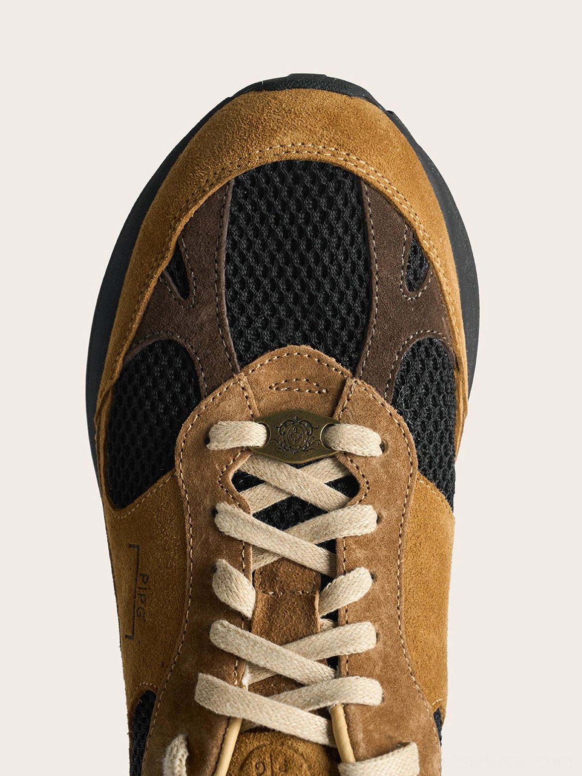 Top view of brown distressed suede trail runner sneaker with cream laces layered suede panels and black mesh