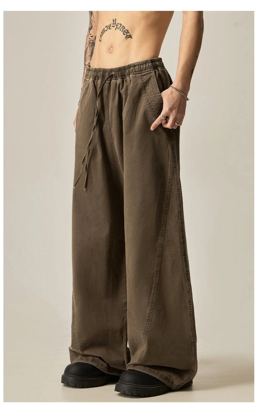 Brown drawstring wide-leg pants front full body view exposed torso tattooed model elastic drawstring waist side pockets washed cotton