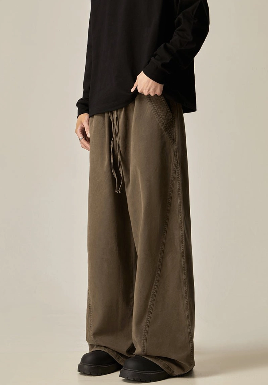 Brown drawstring wide-leg pants front left three-quarter view drawstring waist visible side stitching relaxed oversized fit