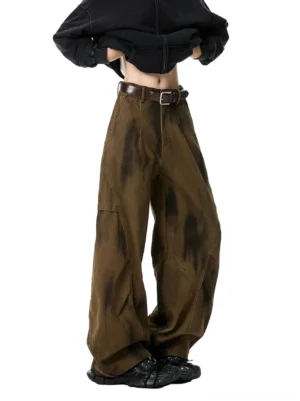 Brown faded tie-dye utility wide-leg pants shown from a low-angle front view with an ultra high-waisted fit, structured seams, cropped black hoodie, and leather belt