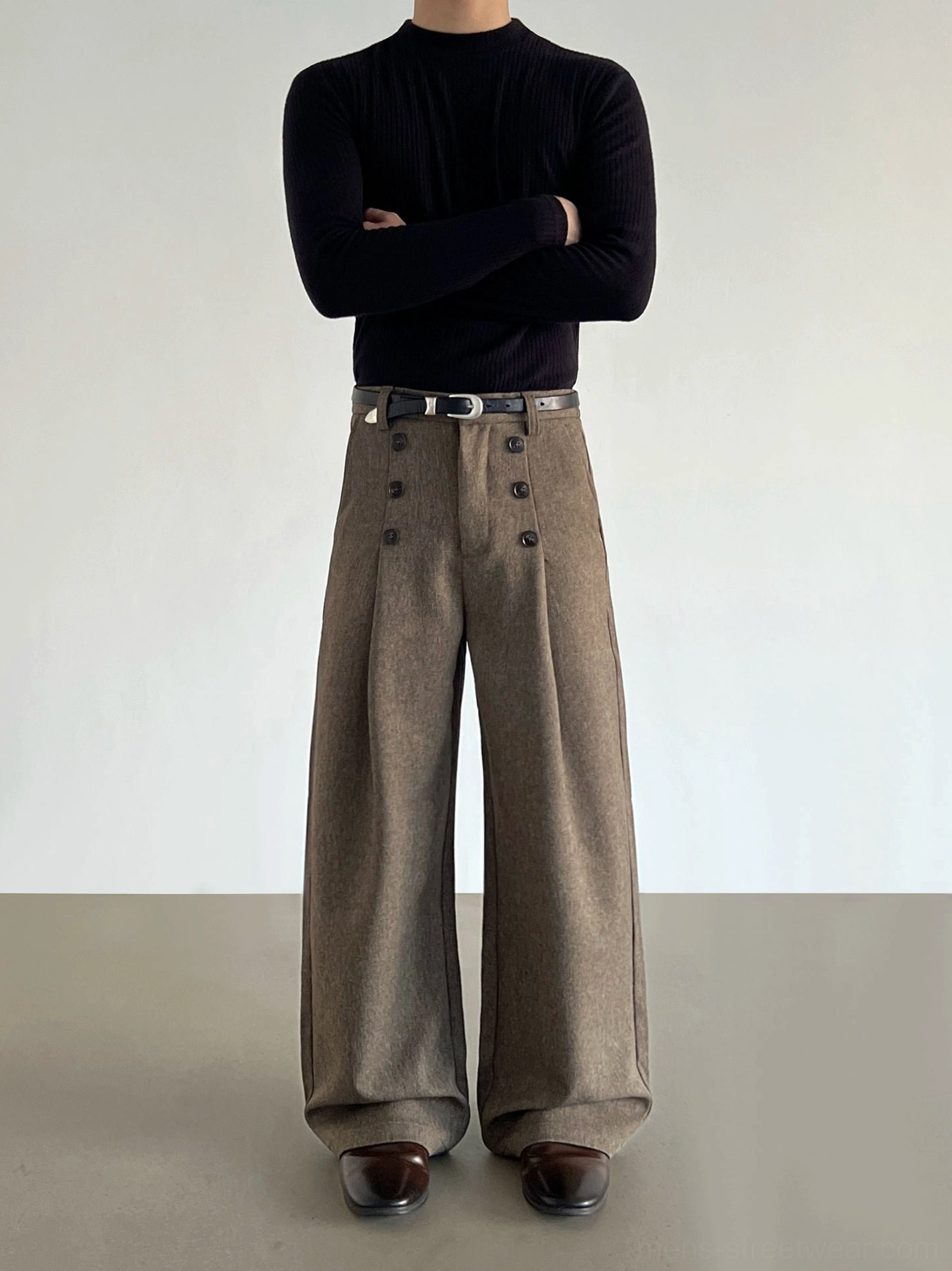 Front full-body view of brown high-waisted double-button wide-leg trousers with pleats, leather belt, black turtleneck, and brown leather shoes