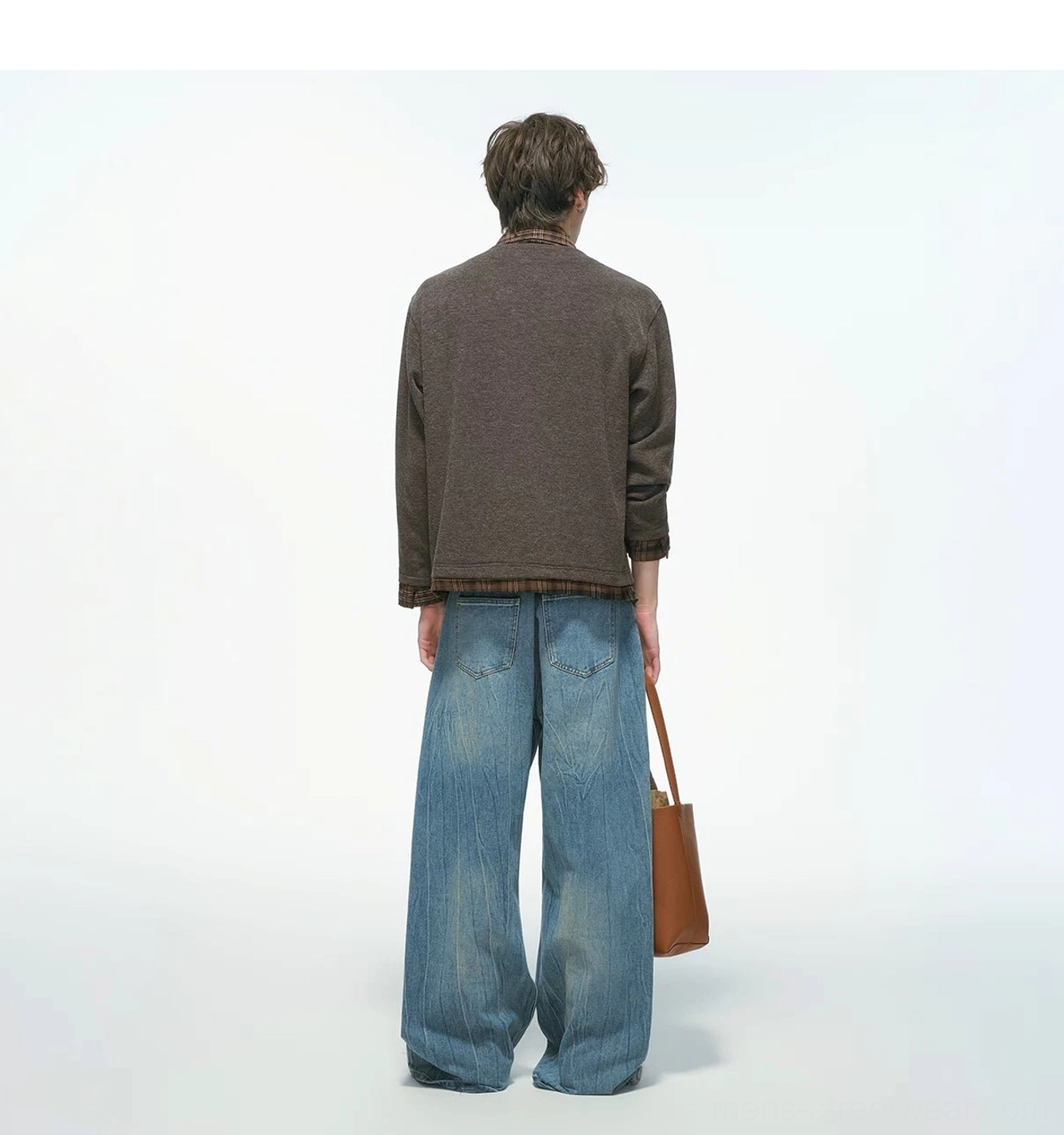 Back view of a brown plaid collar layered knit shirt jacket showing the exposed plaid hem detail with wide-leg jeans