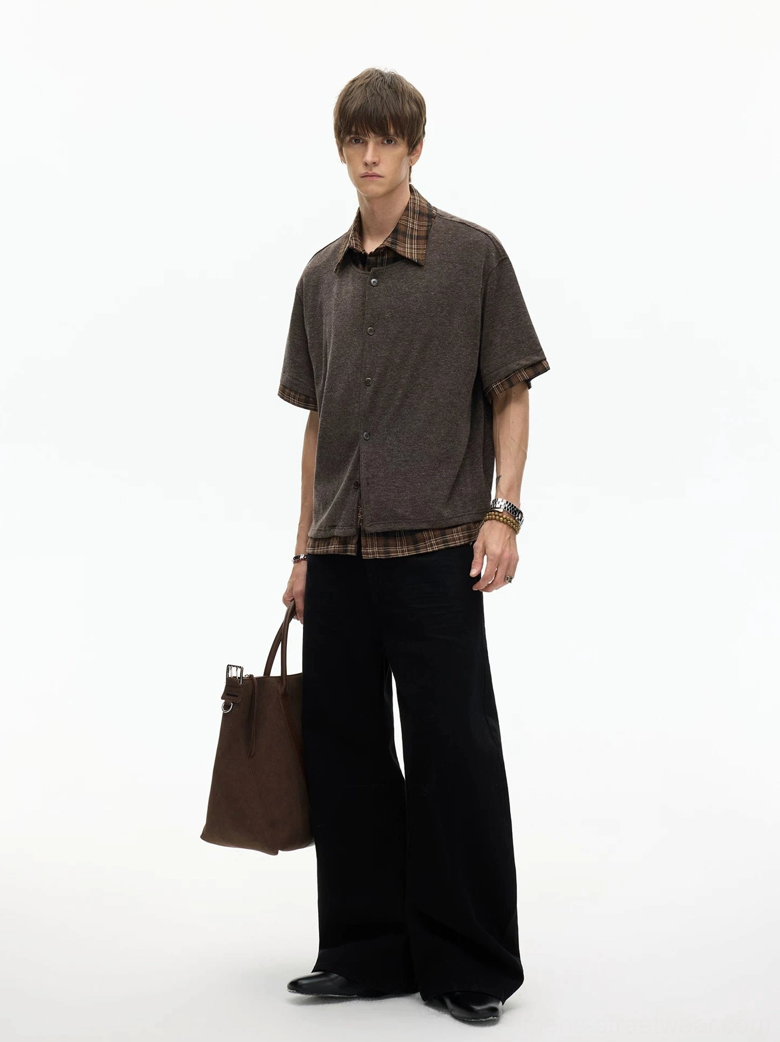 Brown layered plaid hem knit shirt side profile styled with black wide-leg trousers and tote bag