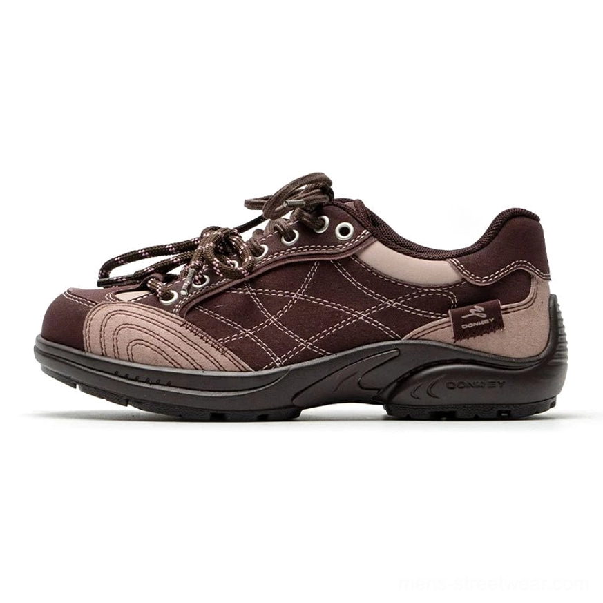 Two-tone brown and pink retro runner sneakers with mixed texture upper, patterned laces, crisscross stitching, and brown rubber outsole