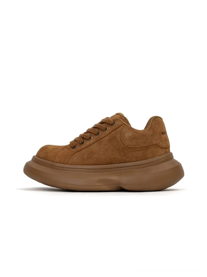 Brown suede chunky platform sneaker in side view with round toe, solid-color upper, thick rubber sole, and subtle heel detail