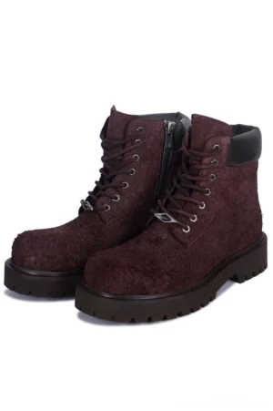Dark brown suede combat boots with chunky black lug soles and side zipper, shown in a front three-quarter studio view