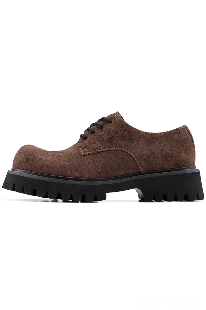 Side profile of a brown suede derby shoe featuring five-eyelet lacing, tongue tag, and rugged black lug sole