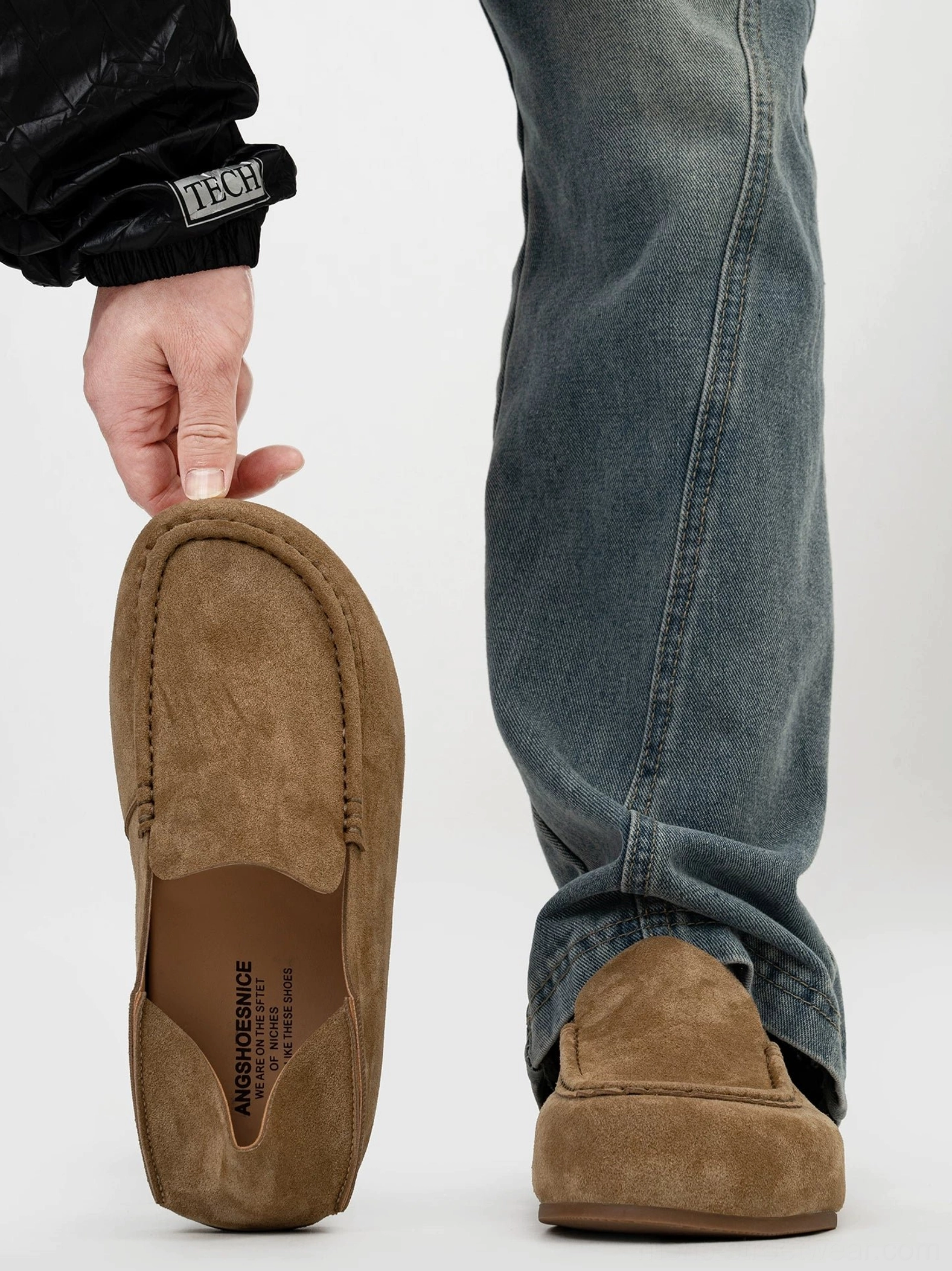 Brown suede driving loafers showing the rear profile, moc toe stitching, cushioned insole, and slip on design