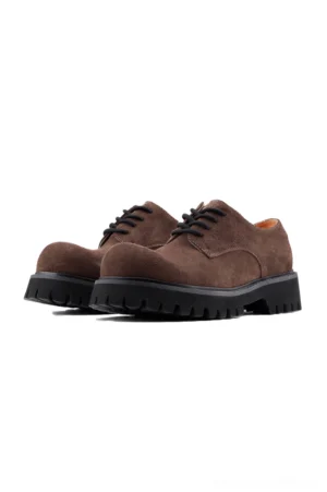 Front three-quarter view of brown suede lug-sole derby shoes with black chunky EVA outsole and flat black laces
