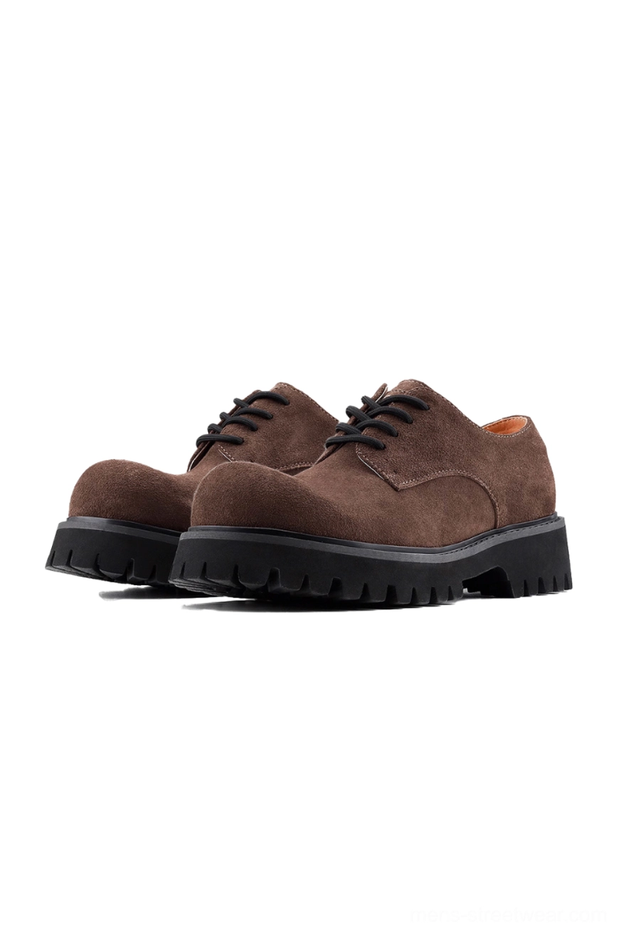 Front three-quarter view of brown suede lug-sole derby shoes with black chunky EVA outsole and flat black laces