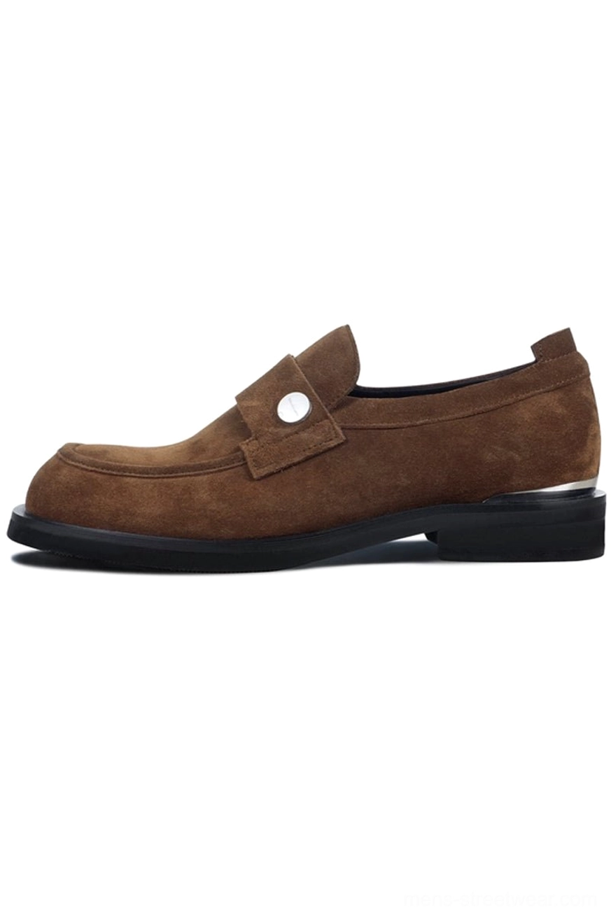 Brown suede penny loafers with matte textured upper silver metal strap square toe and metallic block heel on white background