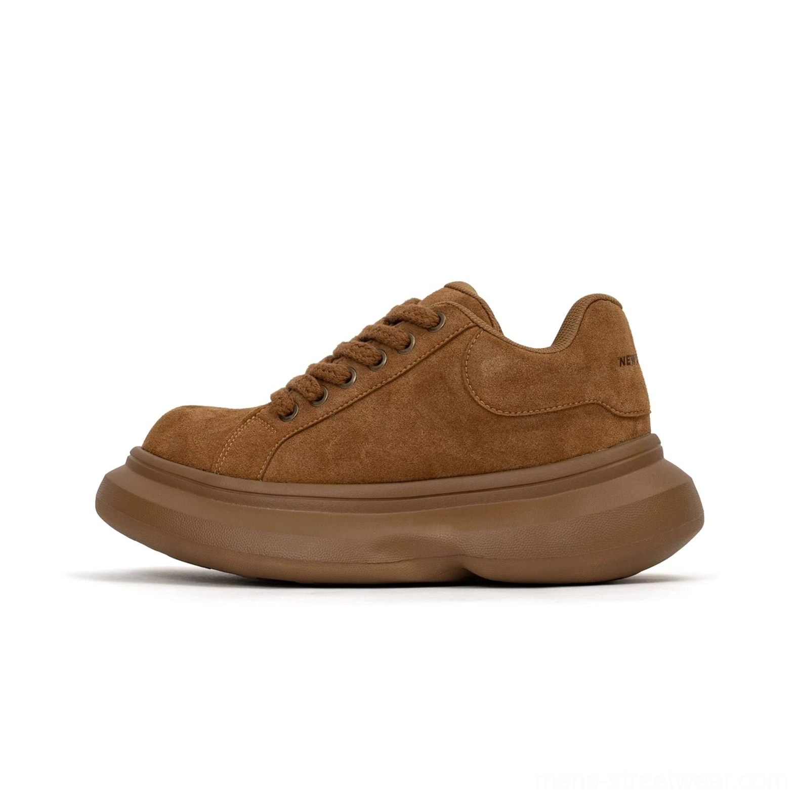 Brown suede platform sneaker close-up from the side showing thick rubber sole, textured upper, round toe, and subtle side logo detail