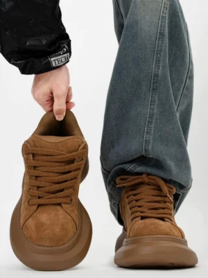 Brown suede platform sneakers shown from a low front angle with chunky wave sole, round toe, lace-up closure, and relaxed Korean streetwear styling