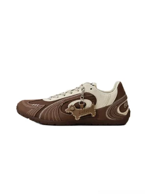 Brown and cream swirl panel retro trainers shown from a side view with stitched overlays and detachable dog pendant