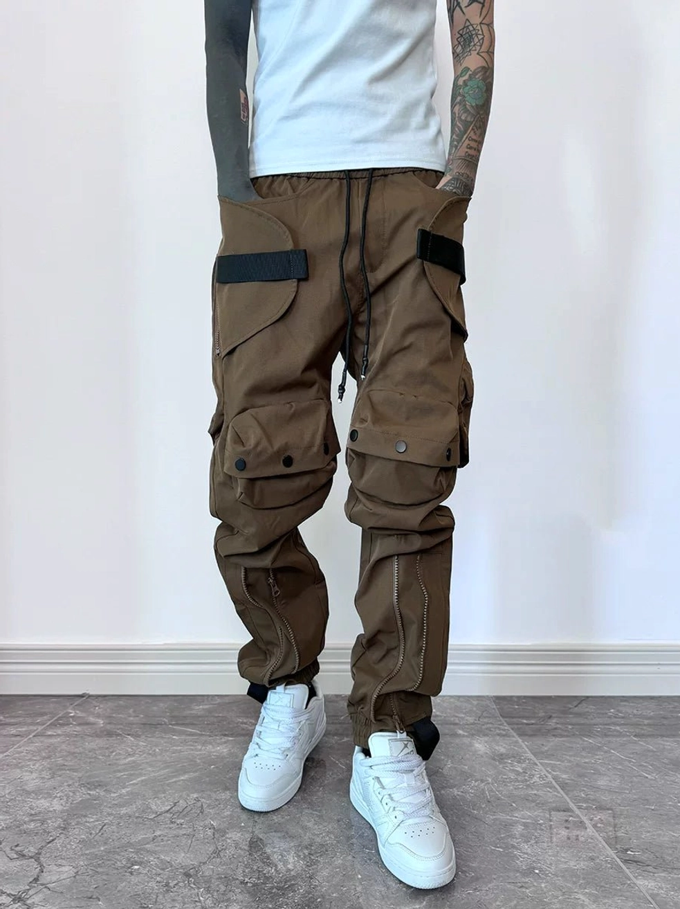 Brown techwear cargo joggers front view with multi-compartment pockets, webbing straps and side zippers
