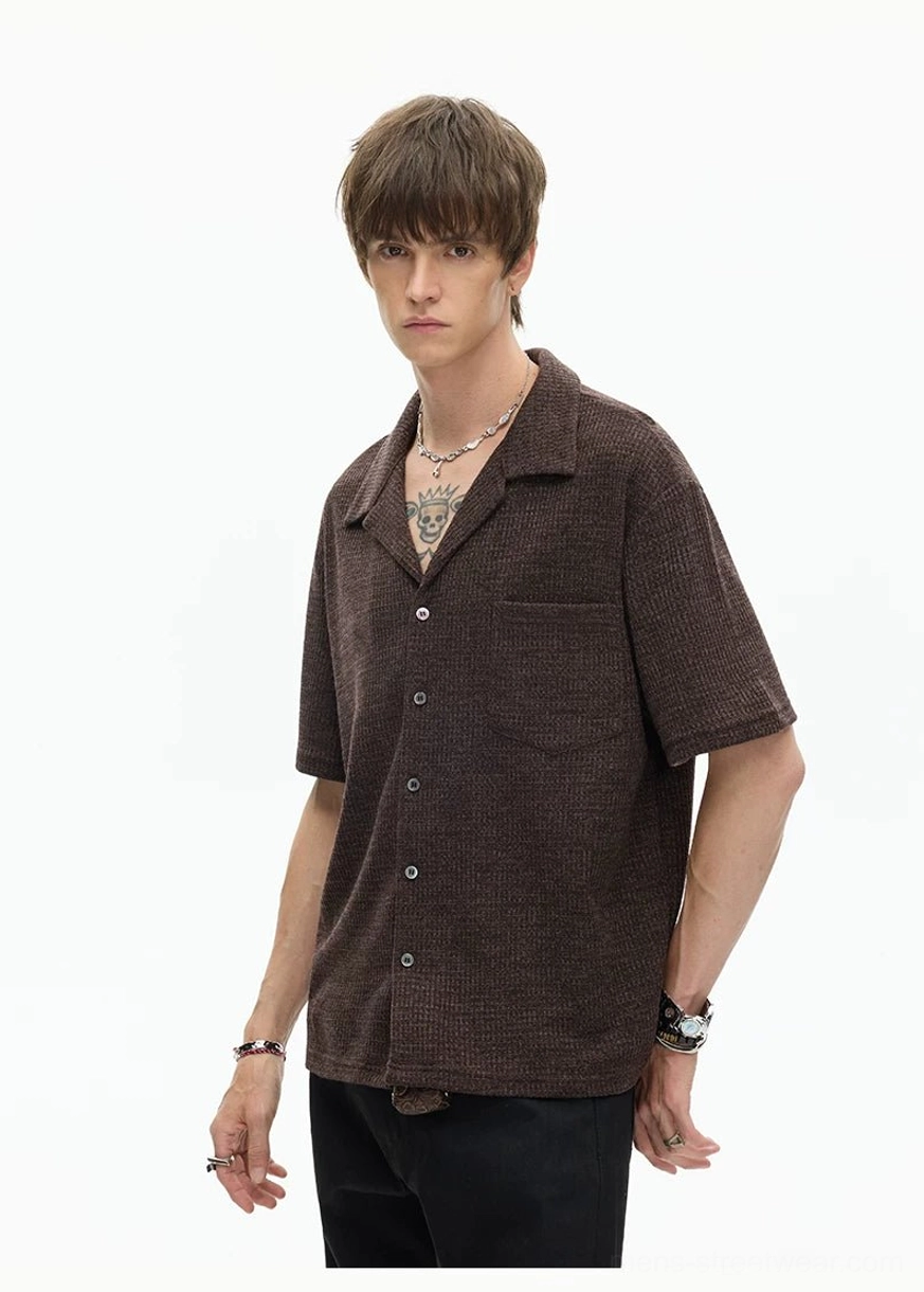 Brown textured camp collar shirt three-quarter view with short sleeves, chest pocket, straight hem, and modern streetwear styling
