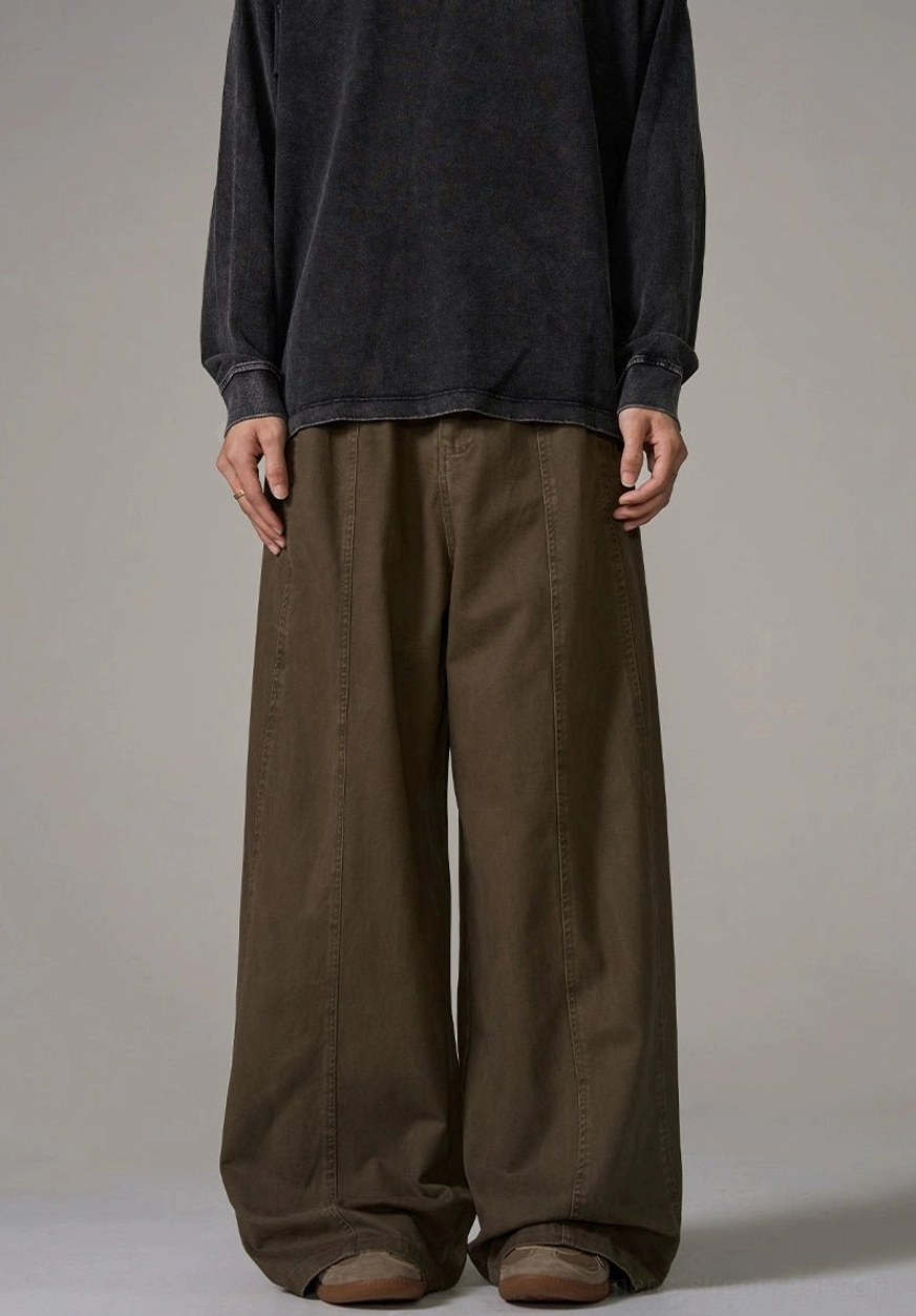 Front view of brown wide-leg cotton trousers on male model showing matte fabric texture and relaxed Acubi fashion silhouette
