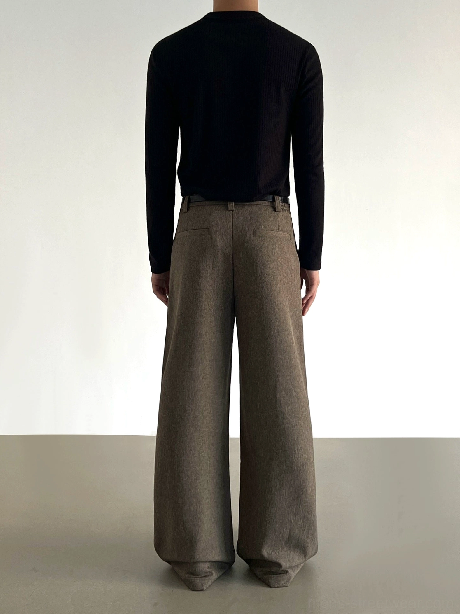 Back view of brown wide-leg trousers showing rear pockets, belt loops, full-length drape, and heathered tailored fabric