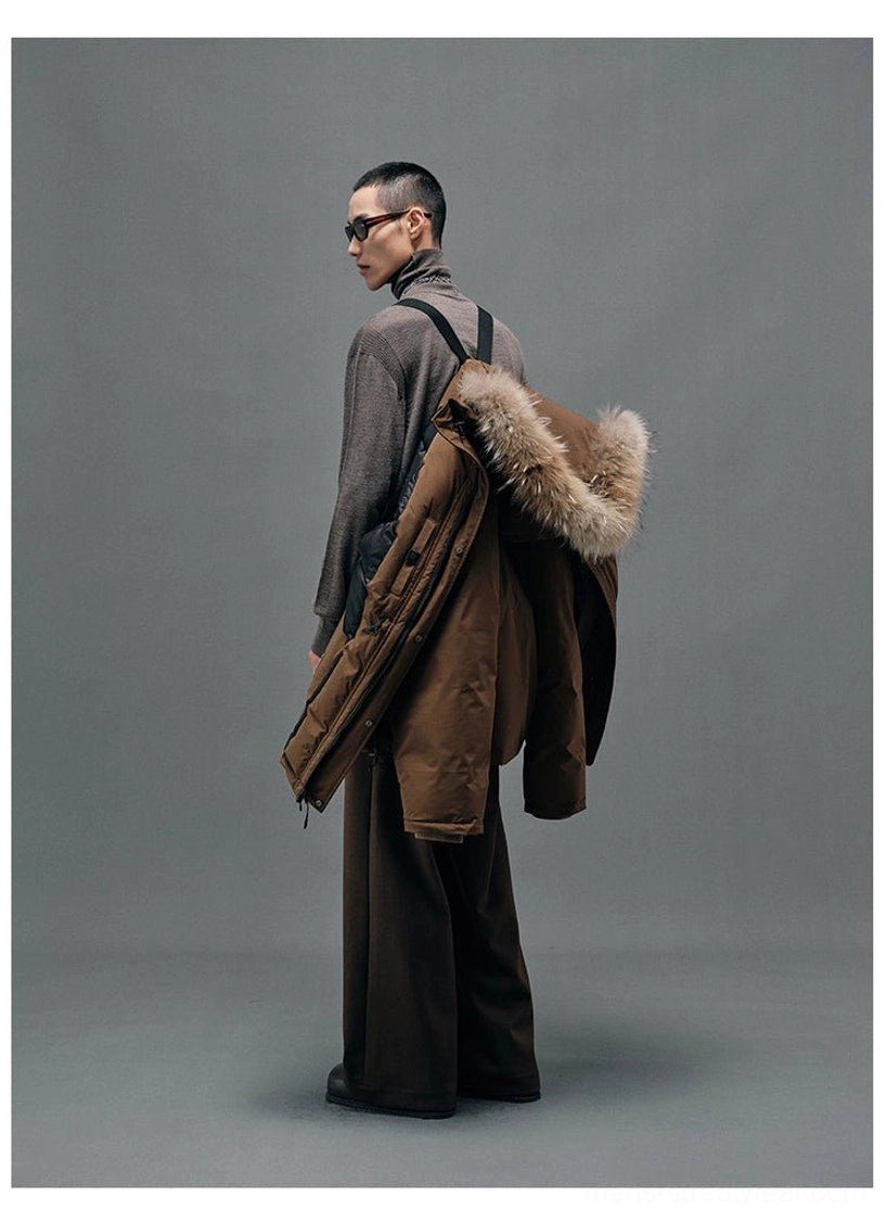 Brown winter down coat draped over the shoulder showing its rear construction, hood and detachable fur collar