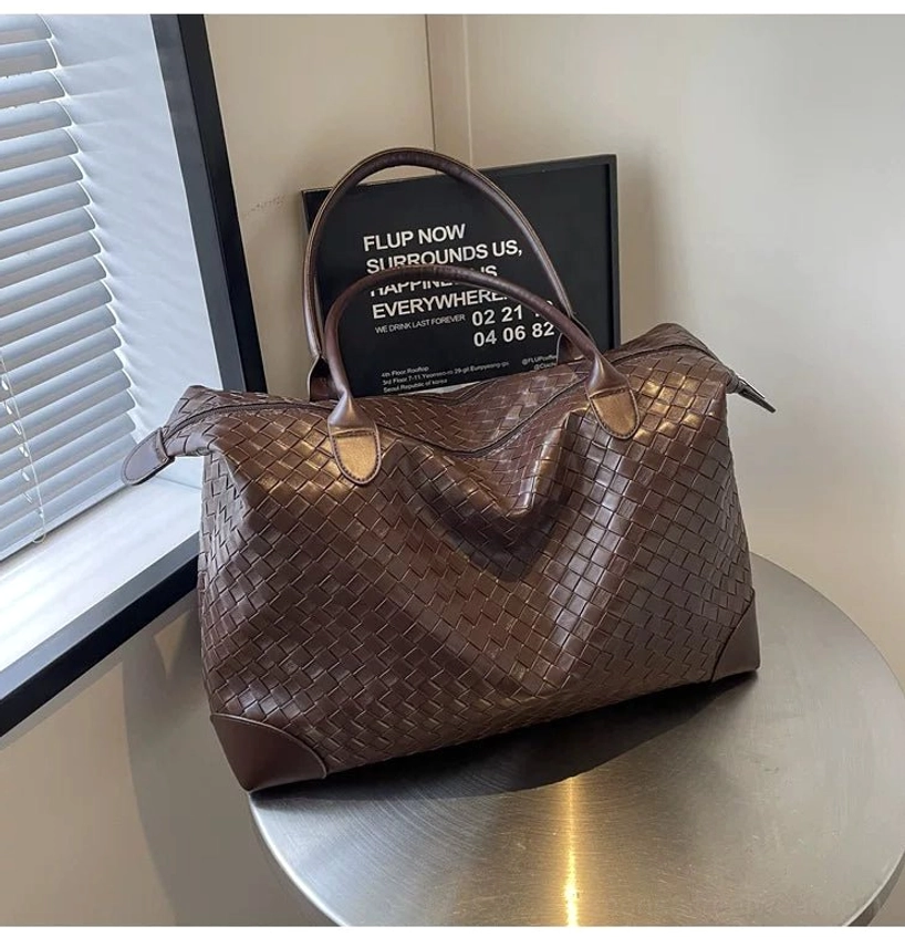 Front three-quarter view of brown woven PU leather weekender tote bag for men with leather-look corner trim