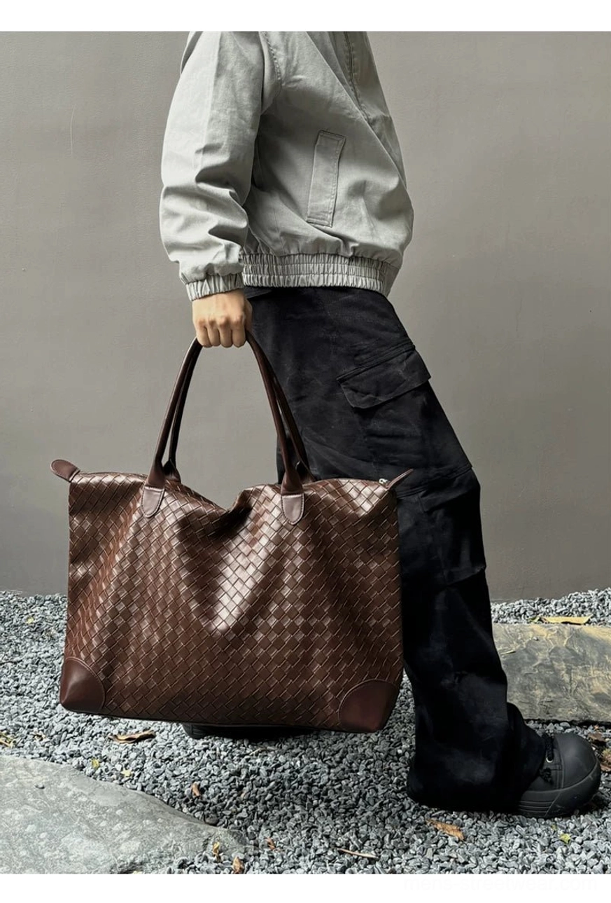 Brown woven PU leather weekender tote bag for men hand carried in side profile view