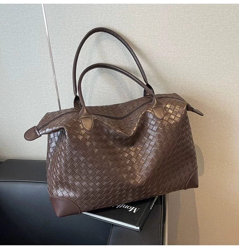 Brown woven PU leather men’s weekender tote bag with relaxed slouchy silhouette in interior setting