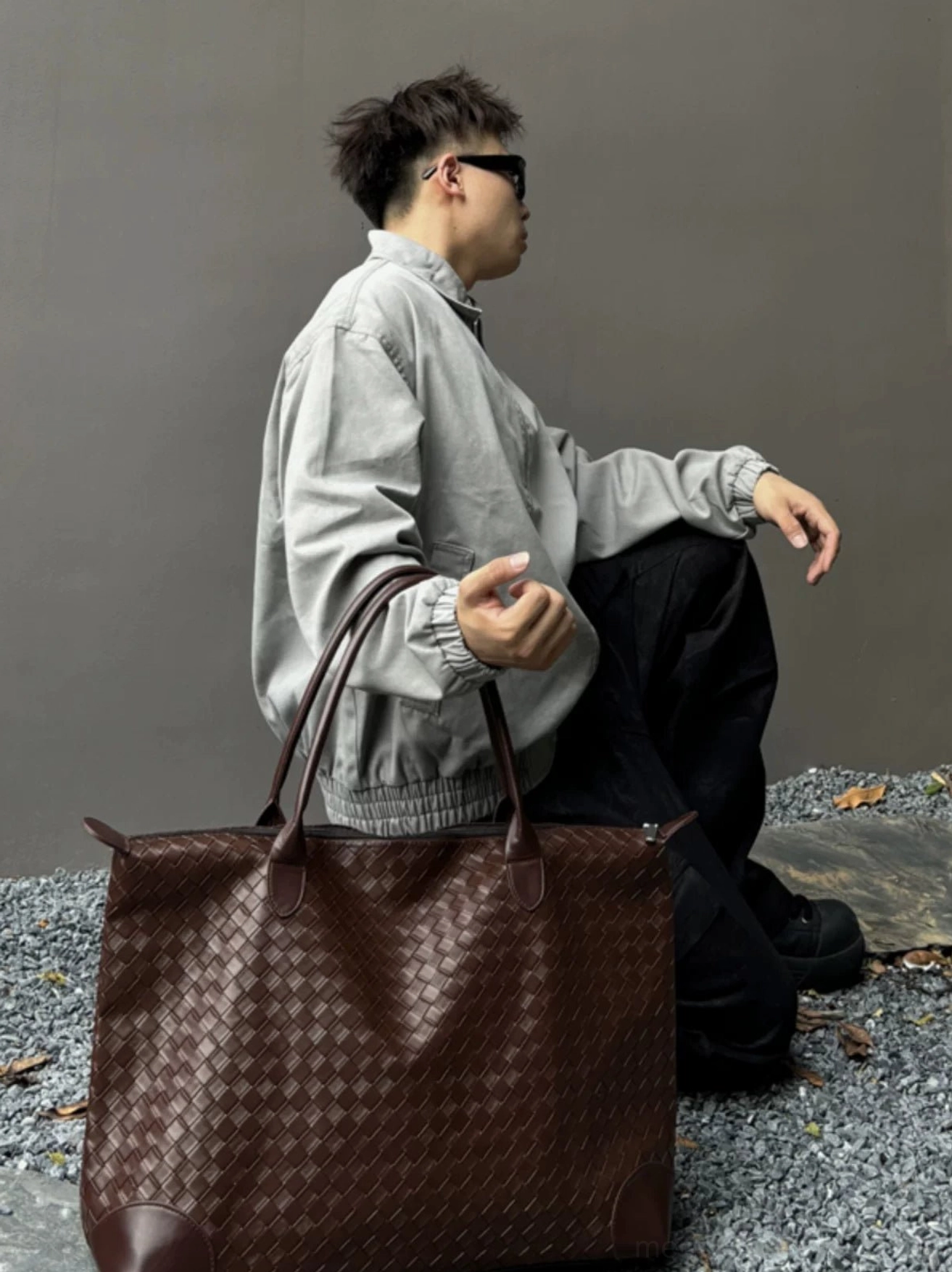 Side profile of brown woven PU leather weekender tote bag for men with reinforced trim