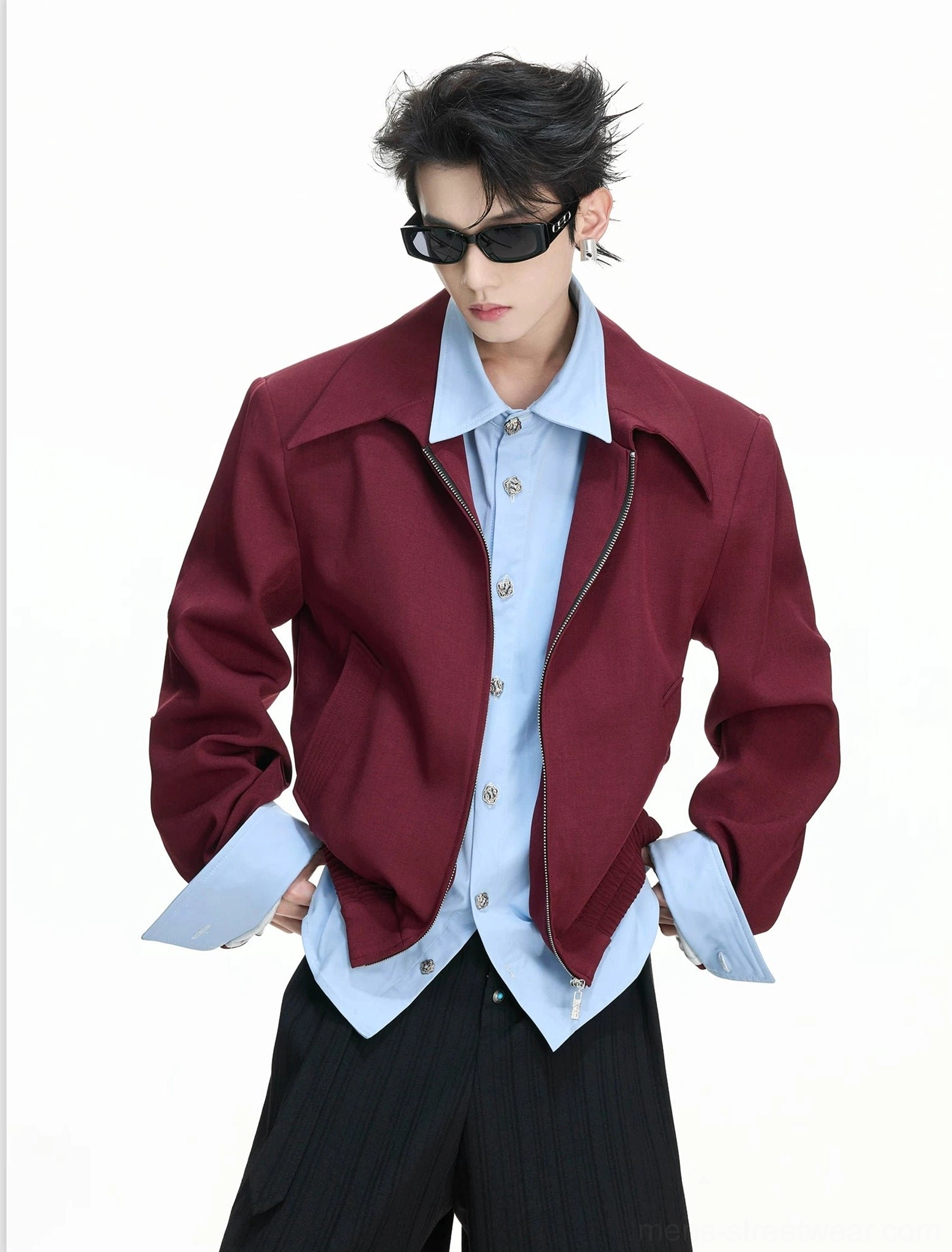 Model wearing a burgundy false-layer collar zip blouson layered over a light blue shirt for a tailored streetwear look