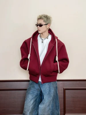 Burgundy oversized textured full zip hoodie with contrast drawstrings and front pockets styled with blue wide-leg jeans
