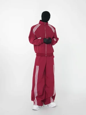 Burgundy red zip-up triple-stripe track jacket and wide-leg pants set front three-quarter streetwear view