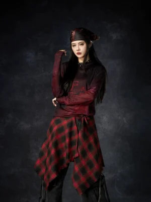 Burgundy washed grunge long sleeve graphic tee styled with a plaid skirt on an alternative fashion model
