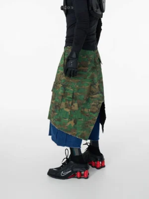 Rear three-quarter view of layered green camouflage denim cargo shorts with raw indigo underlayer and split back hem