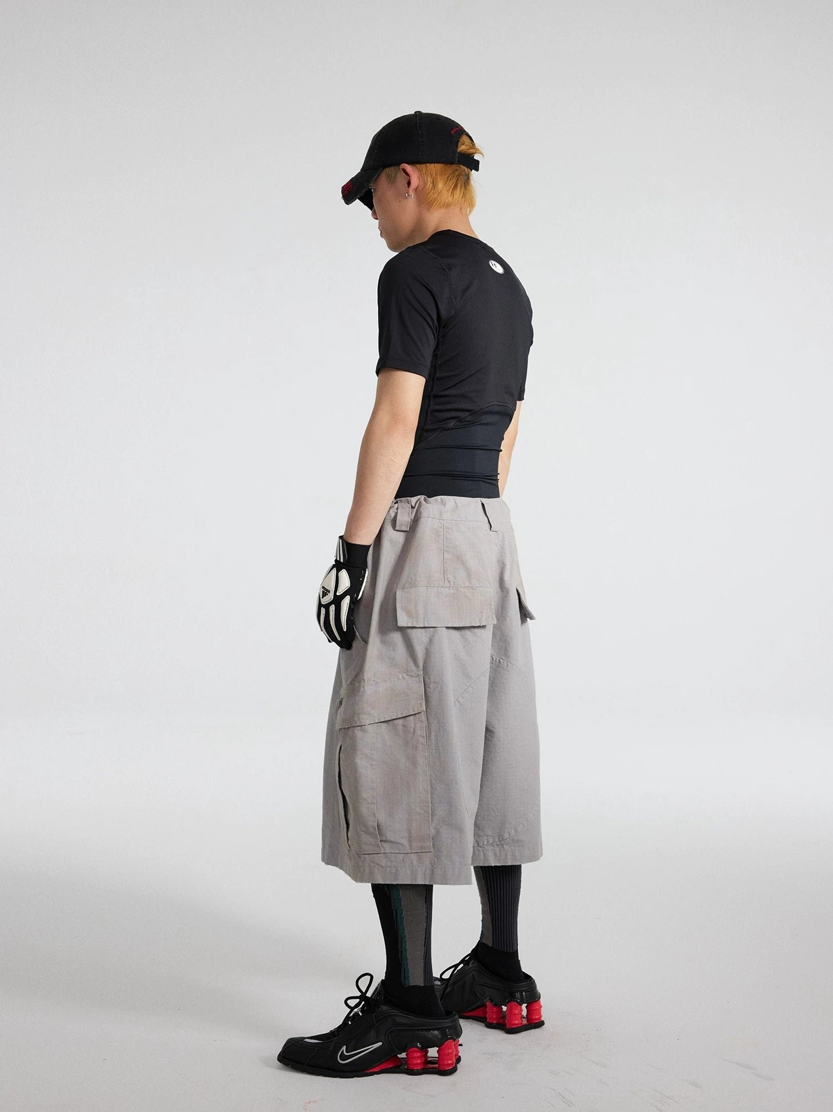 Rear full-body view of cement ash cropped cargo culottes showing oversized back flap pockets and relaxed wide-leg fit