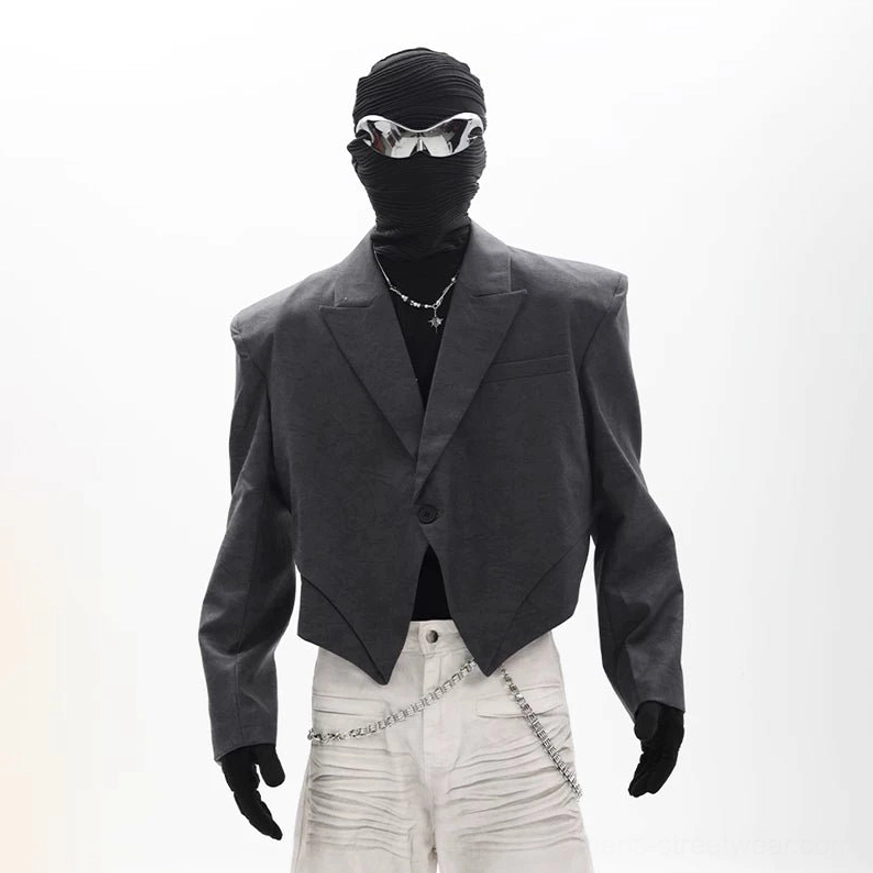 Charcoal gray asymmetric cropped blazer with a sharp pointed hem and relaxed boxy silhouette full body streetwear look