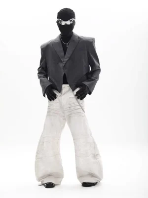 Charcoal gray asymmetric cropped blazer with padded shoulders and pointed front hem styled with white wide leg pants
