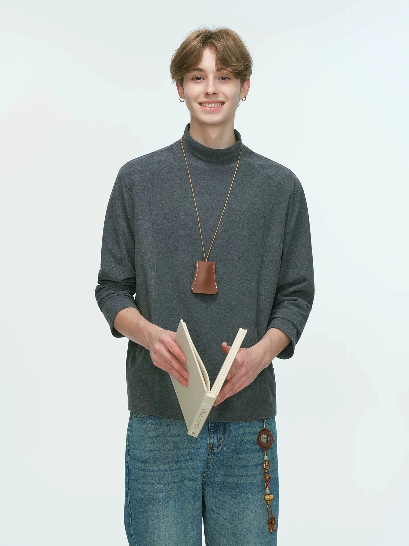 Charcoal gray men's mock neck streetwear top worn with a leather pendant necklace and decorative waist chain on jeans