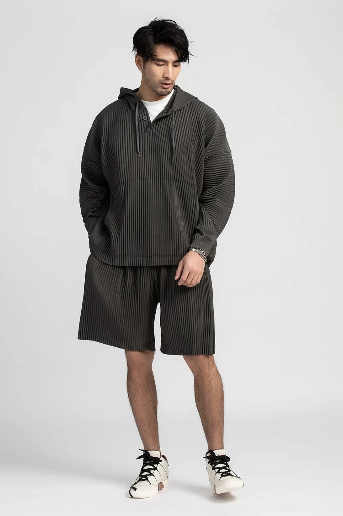 Charcoal gray pleated shorts styled with a matching quarter zip top and layered white inner shirt