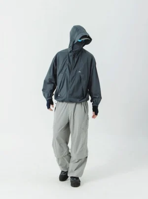 Charcoal gray UV-protective hooded windbreaker with full face-covering zipper hood styled with cargo pants in a modern techwear outfit