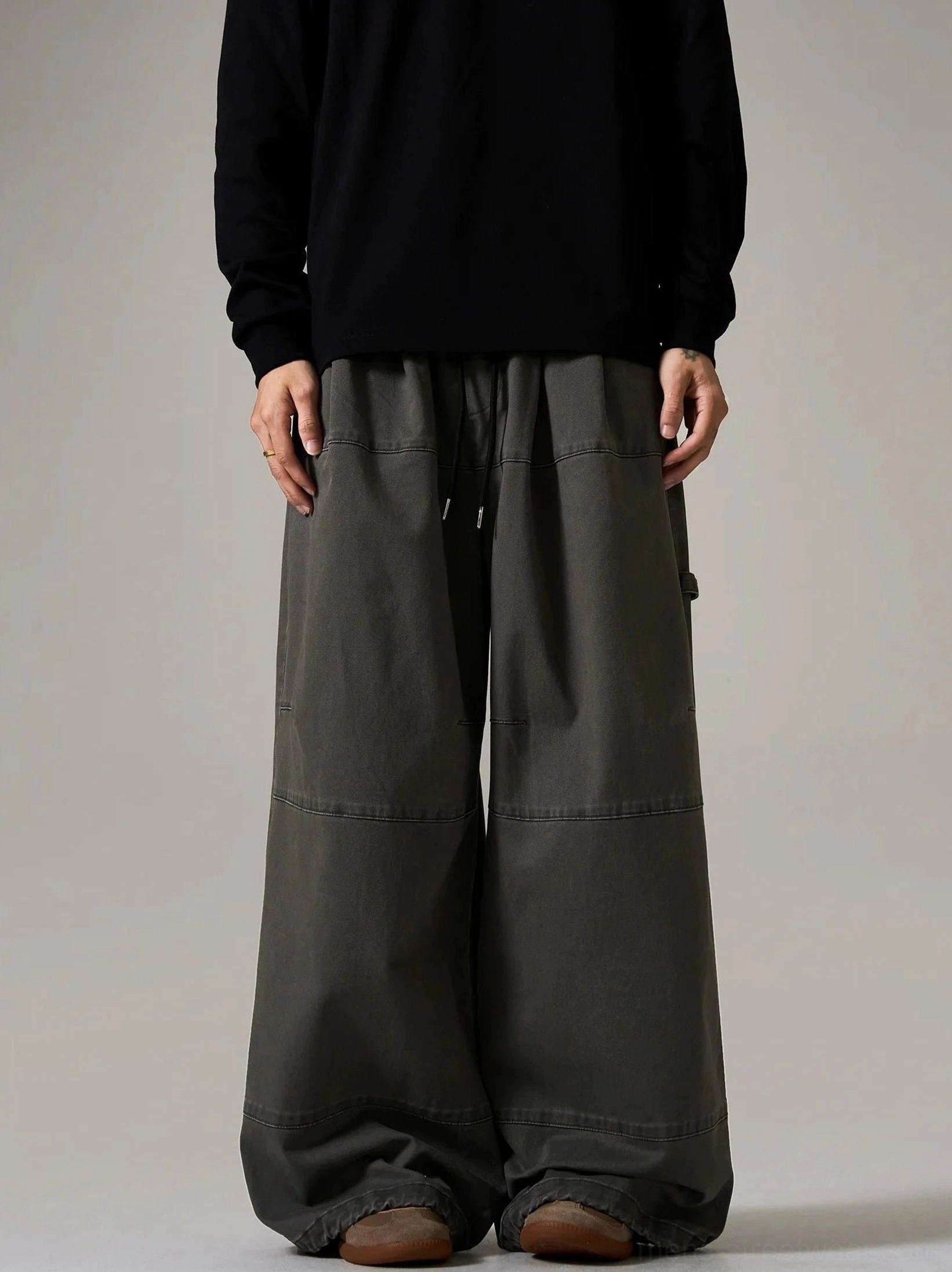Dark charcoal gray wide-leg cargo skater pants with drawstring waist, contrast panel stitching, side utility loop, and relaxed Seoul streetwear silhouette