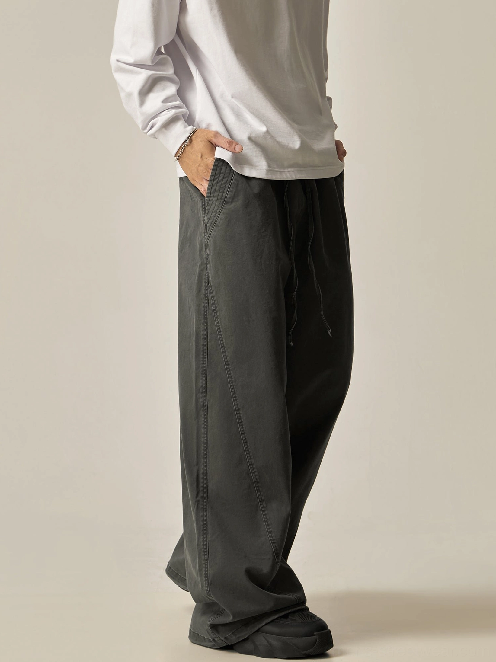 Charcoal grey drawstring wide-leg pants right side three-quarter view washed dark grey fabric curved panel details relaxed