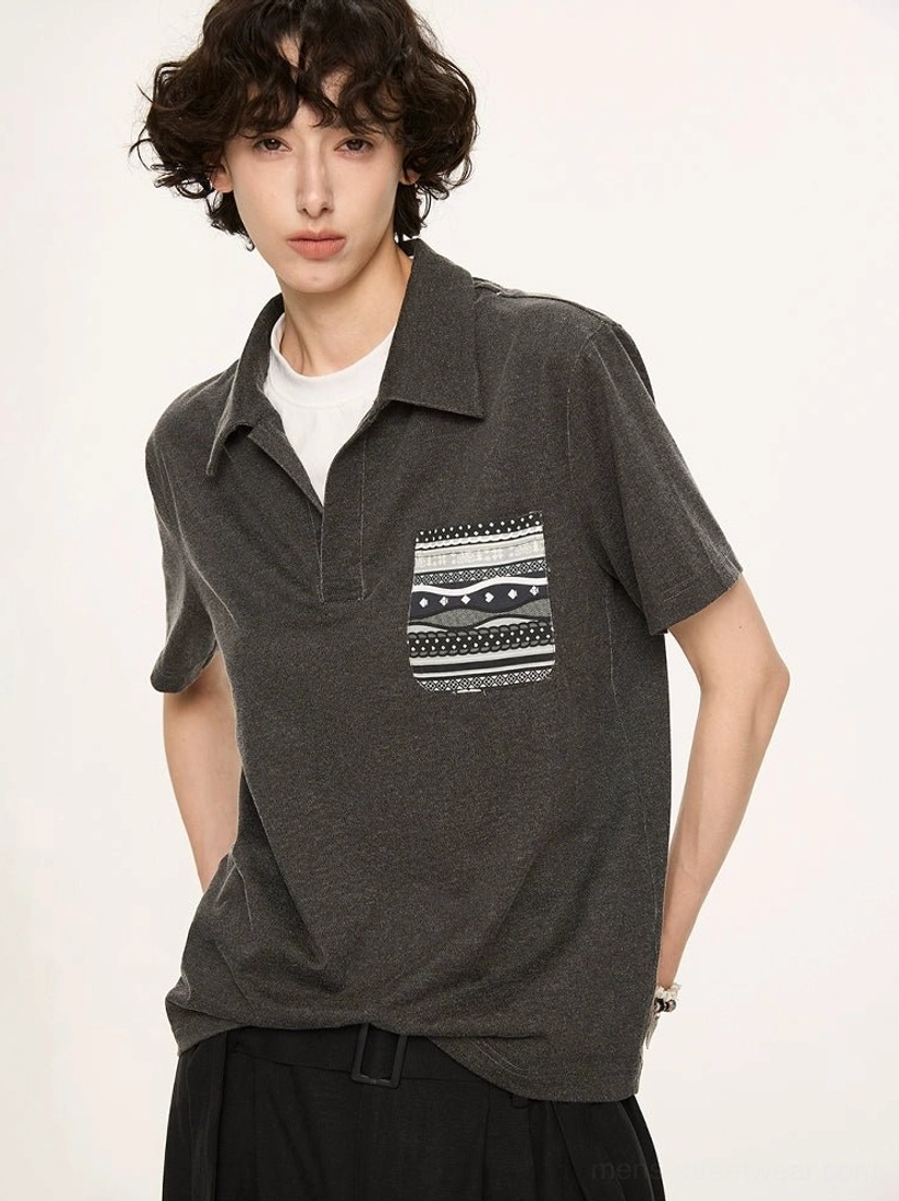 Detailed front view of Fair Isle inspired geometric patterned chest pocket on charcoal grey relaxed polo shirt