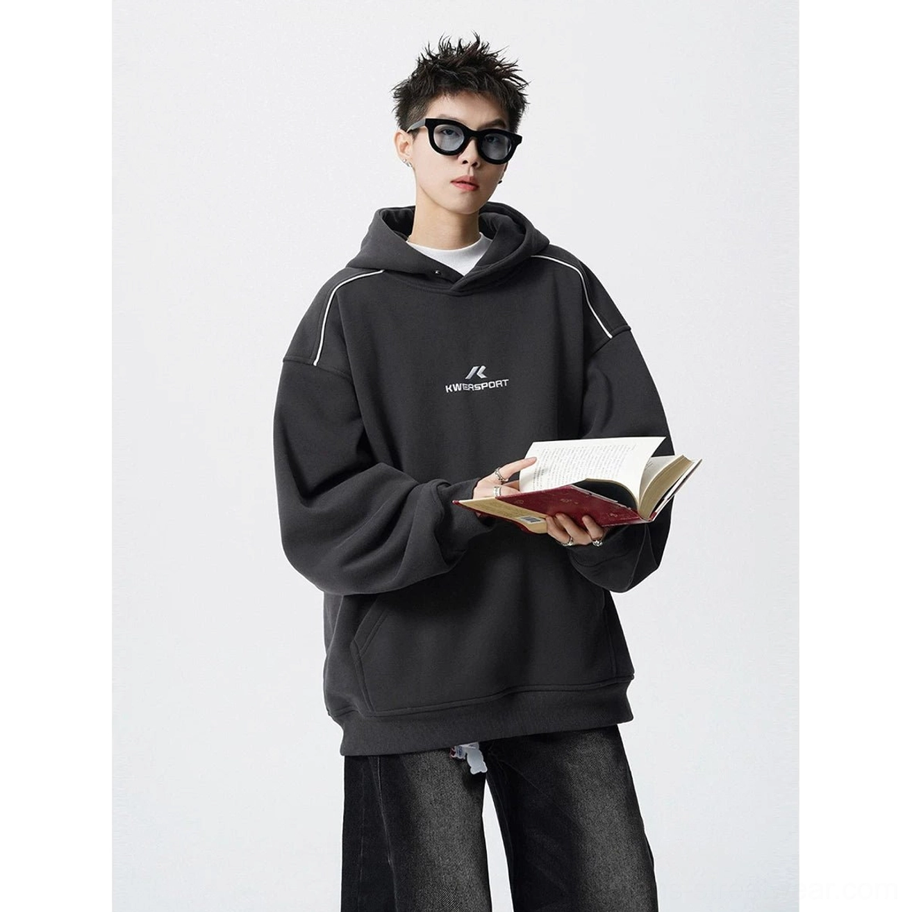 Dark charcoal oversized hoodie with white shoulder piping, embroidered chest graphic, and wide-leg denim Korean fashion styling