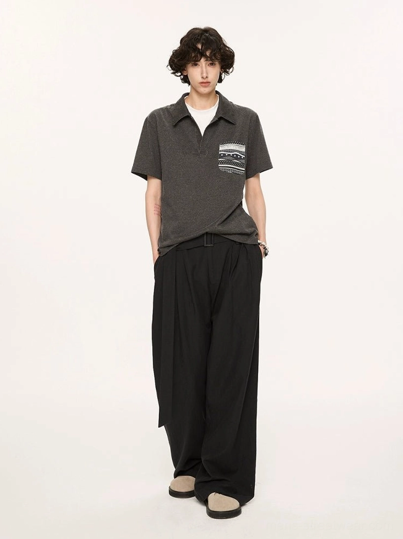 Charcoal relaxed knit polo with Fair Isle inspired chest pocket shown from back three quarter view with black wide leg trousers
