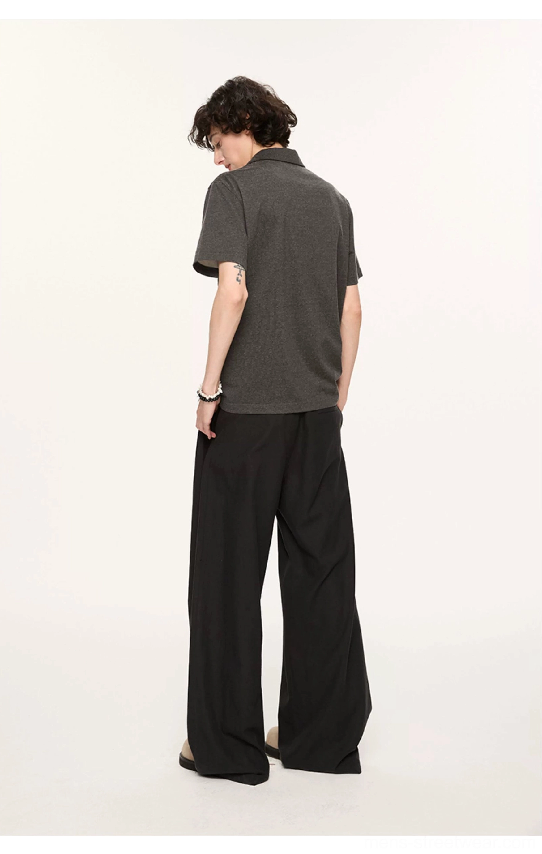 Back view of charcoal grey short sleeve relaxed polo shirt showing clean solid back panel and loose silhouette