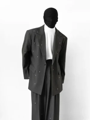 Front three-quarter view of a charcoal gray rhinestone embellished oversized suit set with single-breasted blazer, wide-leg trousers, and white turtleneck styling