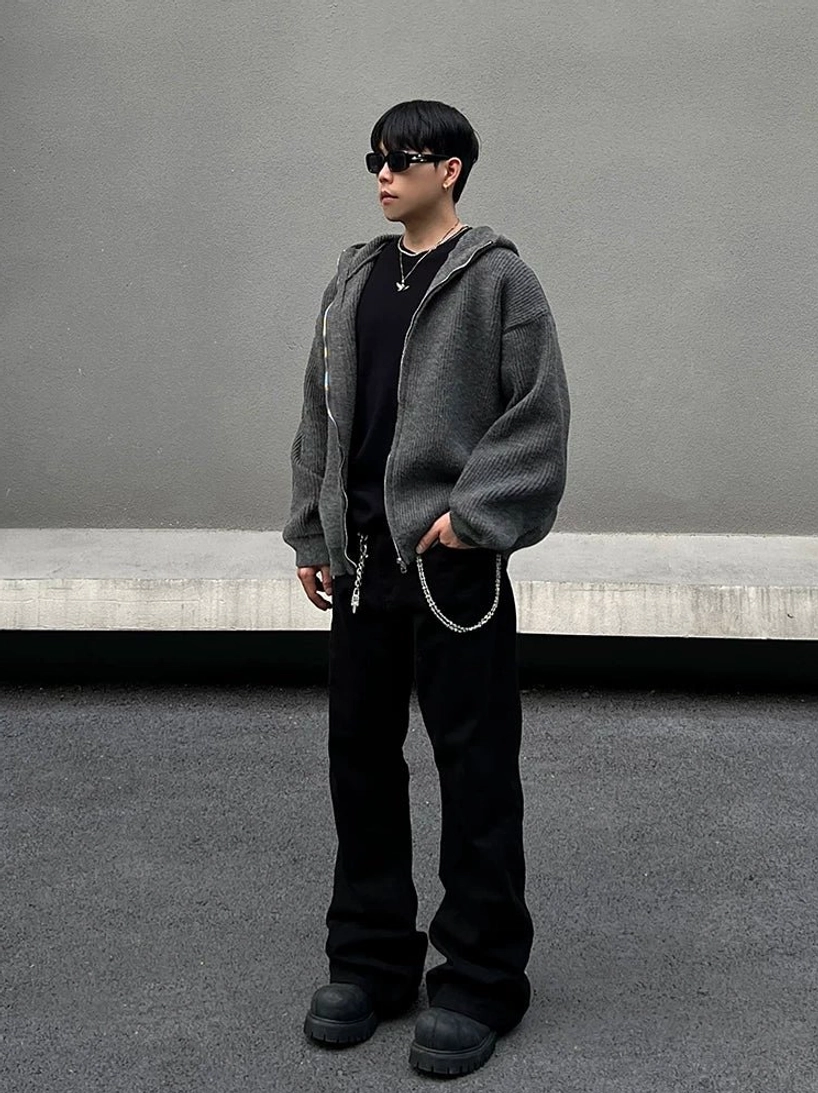Side view of male model wearing a relaxed charcoal rib-knit hoodie with sunglasses silver jewelry and casual Korean streetwear styling
