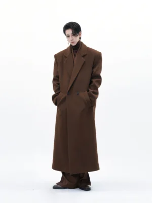 Men's chestnut brown oversized double-breasted wool blend long overcoat front view styled with brown turtleneck and trousers in white studio