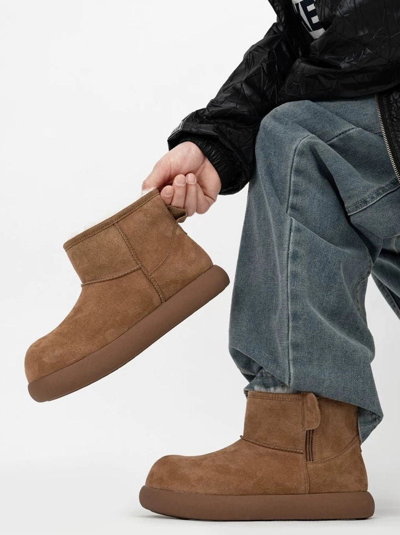 Chestnut brown shearling boot displayed beside a worn boot, showing the suede upper, rounded closed toe, chunky rubber platform, and pull tab